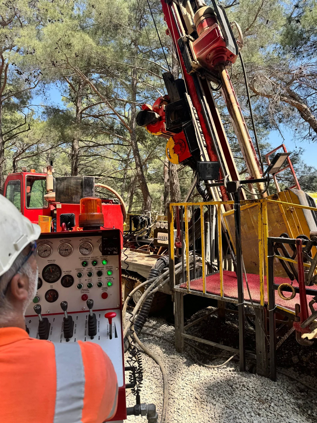 Solid Drill rig and operator at a wooded field site
