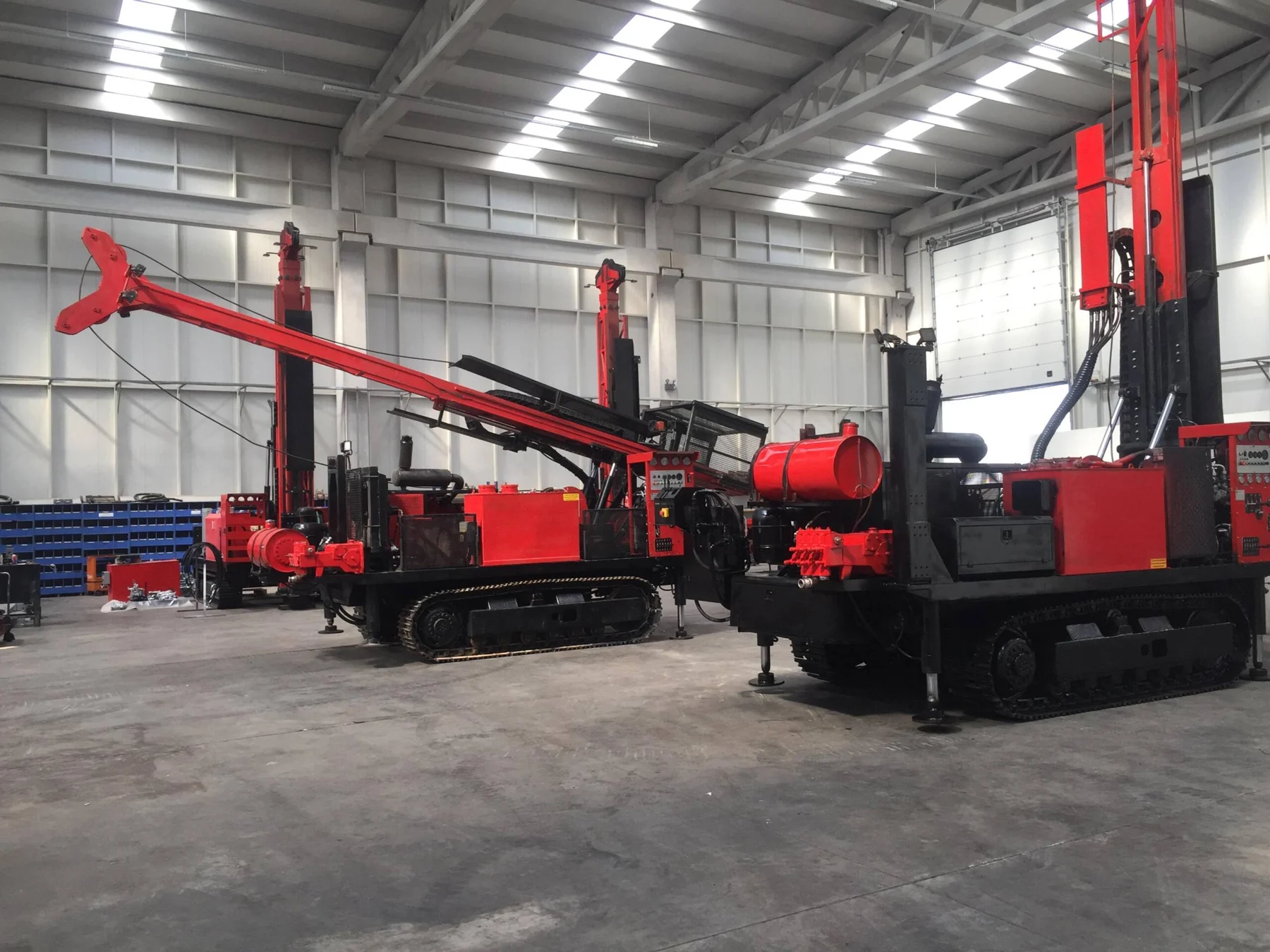 Red tracked drilling rigs inside a build facility